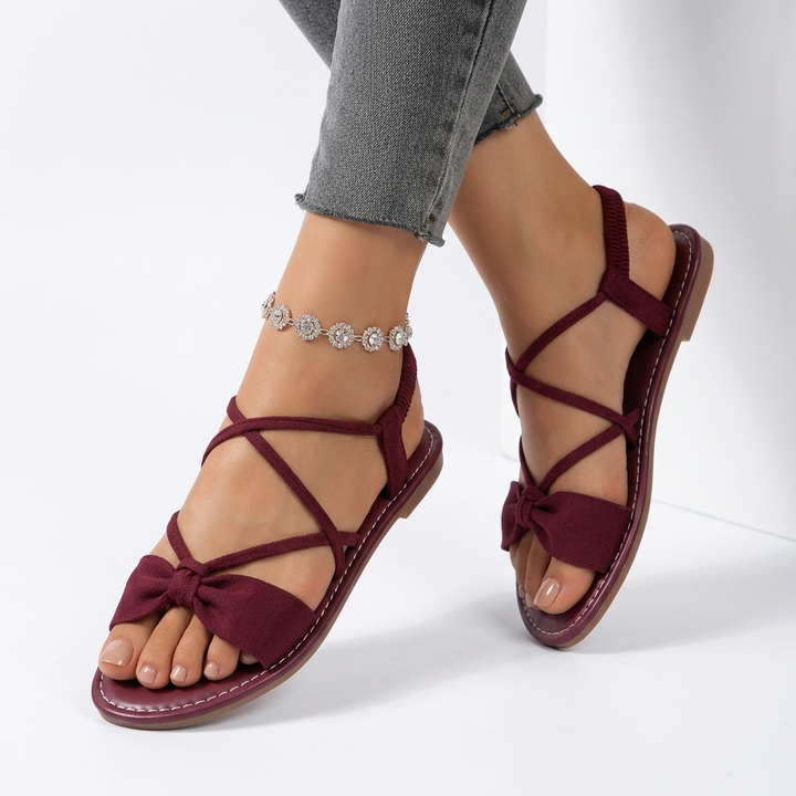 Nouette™ — Flat sandal with crossed lace bow